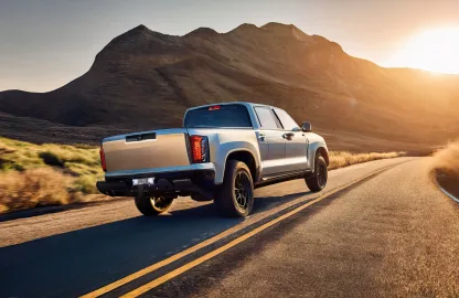 Pick-up de trabalho equipada com acessórios automotivos rodando em estrada ao pôr do sol